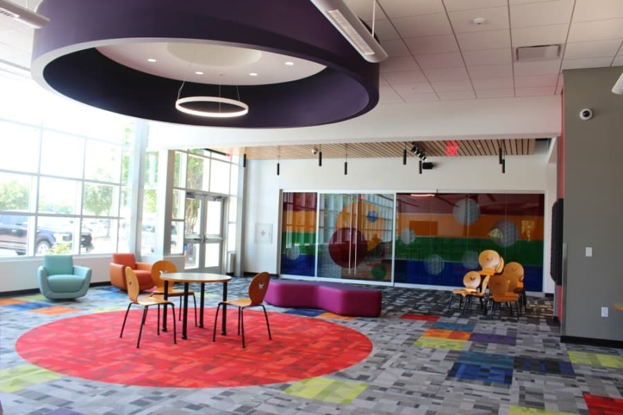 The newly expanded library incorporates more light and color and also provides new technology. The white ring above the chairs provides sound to only the area directly beneath it. (Miranda Jaimes/Community Impact Newspaper)