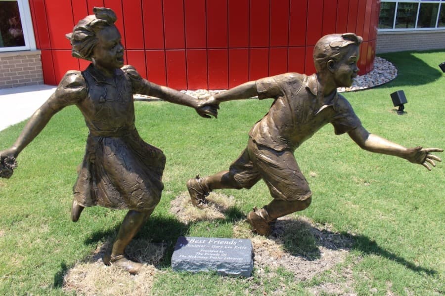 A new bronze statue was installed just outside the library, created by Gary Lee Price. It is called "Best Friends." (Miranda Jaimes/Community Impact Newspaper)