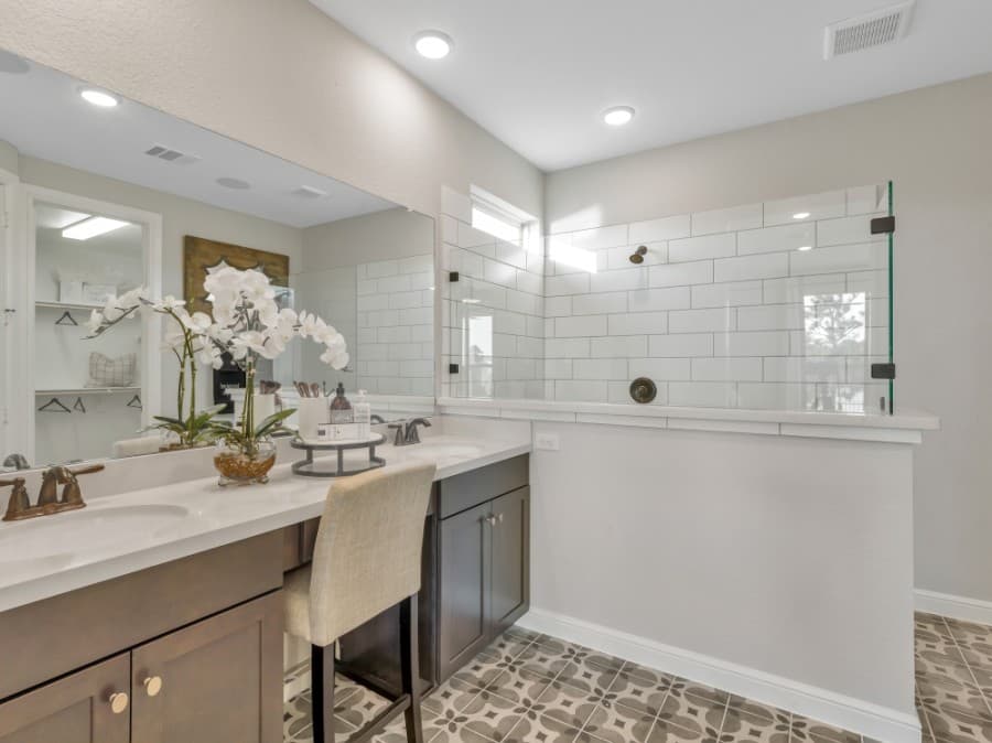 Bathrooms are furnished with ceramic tile floors and shower walls, maple cabinets and chrome faucets. (Courtesy Taylor Morrison)