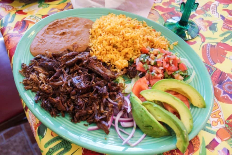 Carnitas plate ($11.50): fried pork served with rice, beans, pico de gallo, tortillas and avocado slices. (Kelly Schafler/Community Impact Newspaper)