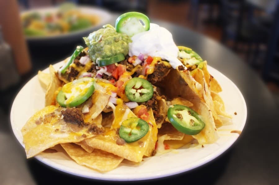 Personal nachos ($9.95) come with melted cheese, tomatoes and refried beans. (Dylan Sherman/Community Impact Newspaper)