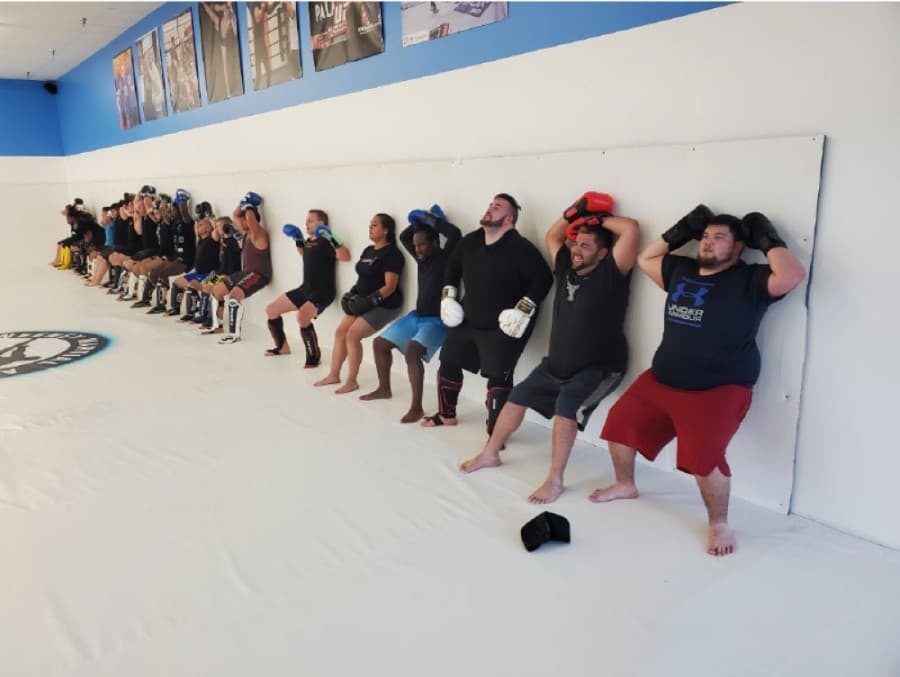 Members perform exercises against a wall while wearing gloves at one of the gym's activity sessions. (Courtesy McSweeney Martial Arts)