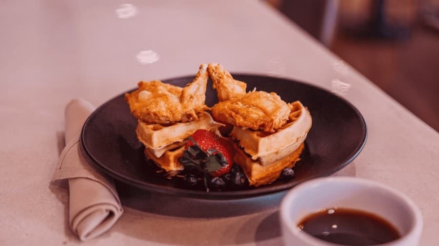 The chicken and waffles come with marinated chicken, fresh berries and hot syrup. (Courtesy Chef Point Bar & Restaurant)