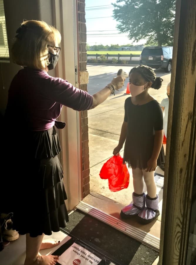 Ann-Marie Brown checks the temperature of dance student Adison Elliott. (Courtesy Bay Area Houston Ballet & Theatre)