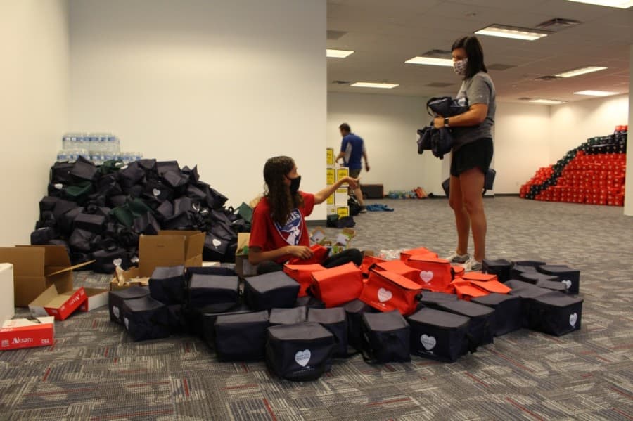 An FC Dallas volunteer (left) packs PPE kits on Sept. 1. FC Dallas was one of 20 businesses that joined the effort. (Elizabeth Uclés/Community Impact Newspaper)