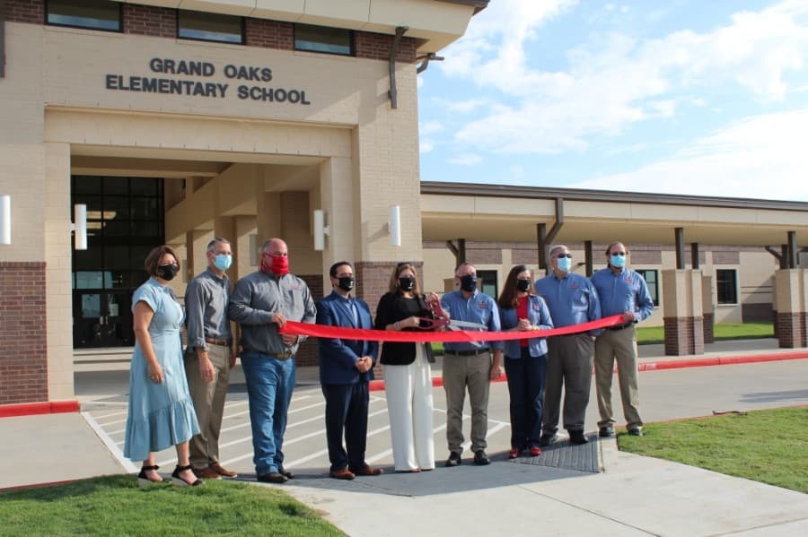 Principal Niesa Glenewinkel (far left), Superintendent Martha Salazar-Zamora (center) and the Tomball ISD board of trustees gather at the ribbon cutting for Grand Oaks Elementary School on Sept. 4. (Anna Lotz/Community Impact Newspaper)