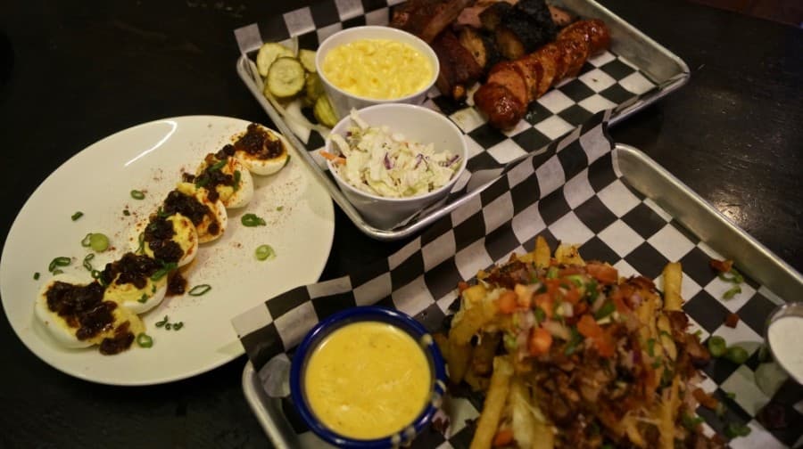 Customer favorites include Liberty Barbecue's deviled eggs appetizer, featuring bacon bourbon jam; smoked meat plates; jalapeno Mac and cheese and coleslaw sides; and Trash Fries, or plate of french fries covered in brisket, cheese, bacon, ranch  dressing and pico de gallo. (Kelsey Thompson/Community Impact Newspaper)