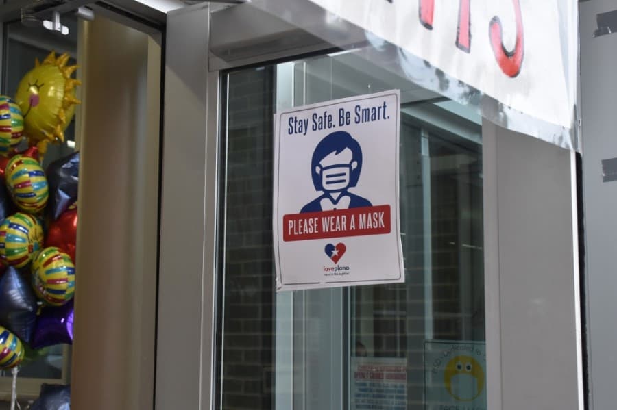 A flyer at one school entrance reminds students and staff to wear a mask. (Makenzie Plusnick/Community Impact Newspaper)
