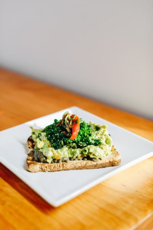 Avocado toast is a vegan option consisting of house-made guac, house pesto drizzle, and massaged kale. $6. (Courtesy Lovebeans Coffeehouse)