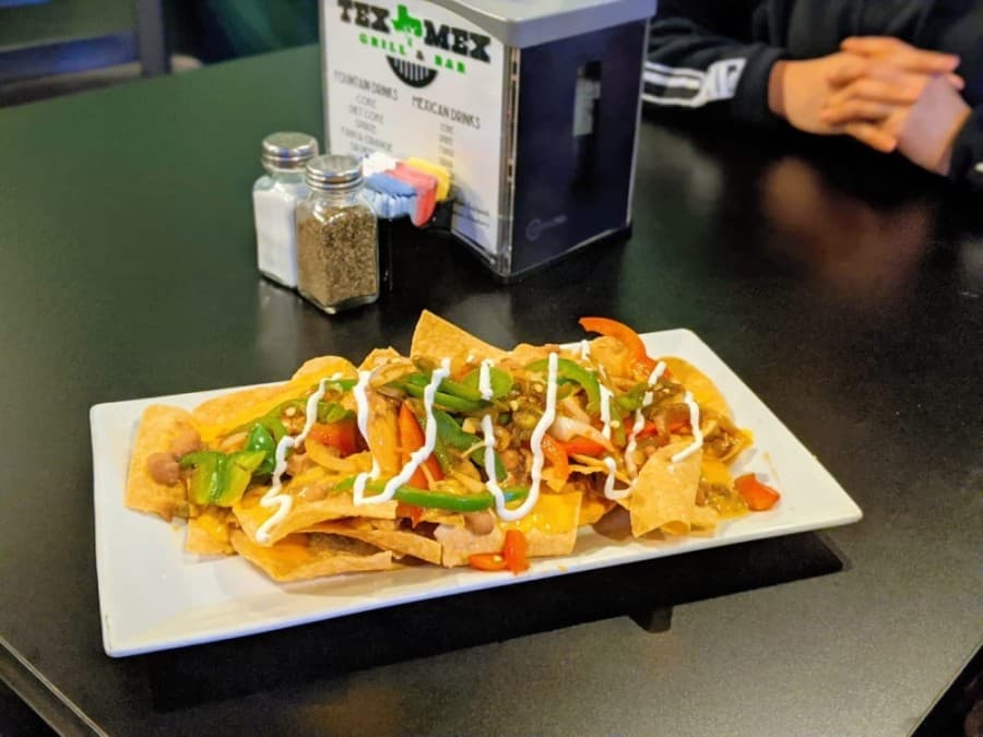 Veggie nachos ($12.75): Fresh tortilla chips are layered with chile con queso and beans, and topped with bell peppers, lettuce, pico de gallo, sour cream and jalapenos. (Courtesy Tex-Mex Grill and Bar)