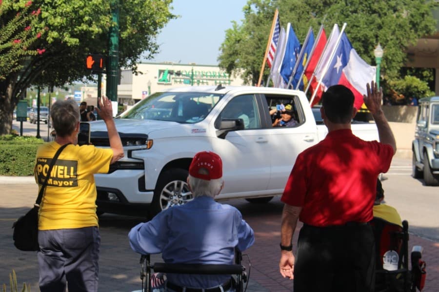 Onlookers wave as the procession goes by. (Eva Vigh/Community Impact Newspaper)