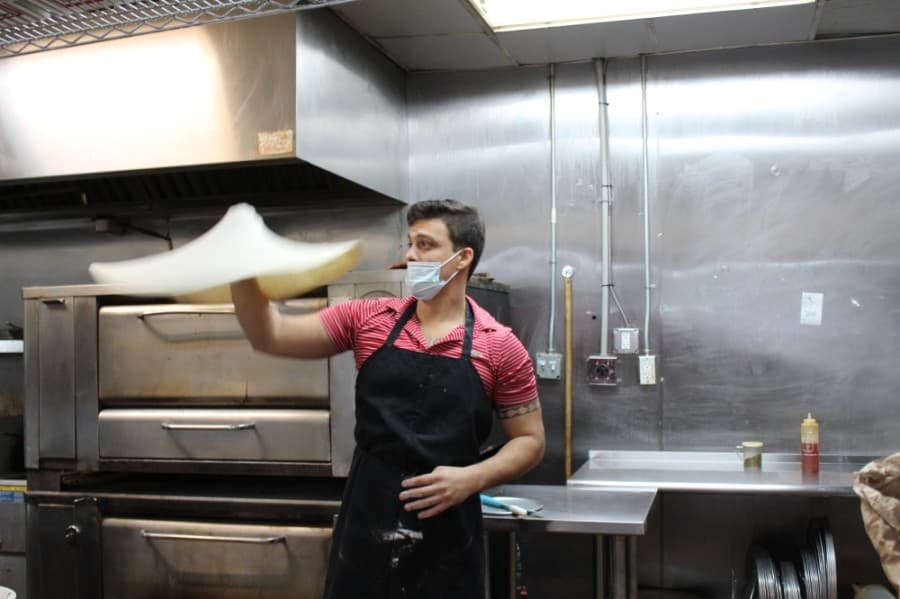 Brazilian head chef Vinicius Fernandes spins the pizza dough in the restaurant's kitchen on Sept. 18. (Sandra Sadek/Community Impact Newspaper)