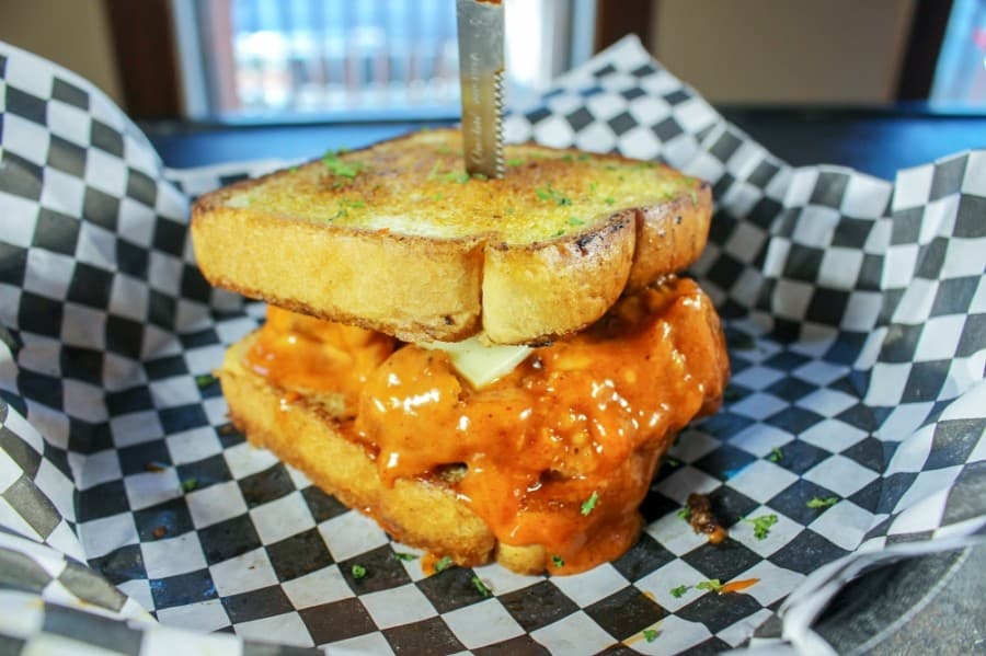 Spicy Honey Butter Mother Clucker (0.99): buttermilk fried chicken thighs covered in spicy honey butter and dusted with cayenne pepper, topped with white American cheese, grilled jalapenos and served on Texas toast. (Kelly Schafler/Community Impact Newspaper)