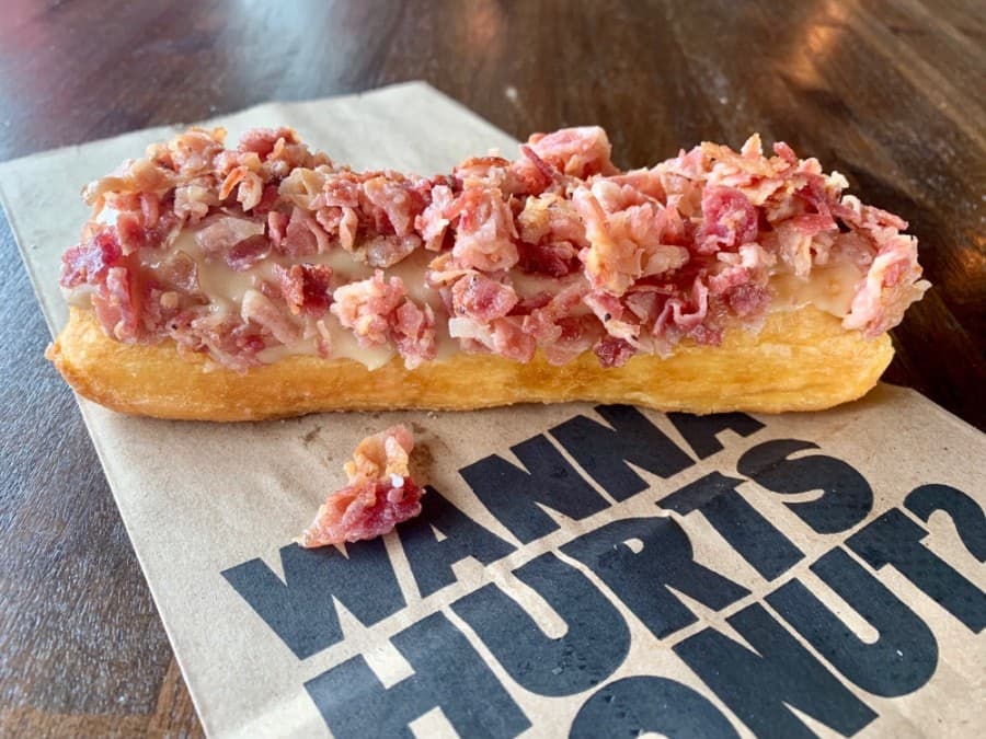 Owner Keith Selby said the Maple Bacon Me Crazy, which is a Long John doughnut with maple icing and bacon bits sprinkled on top, is one the most popular selections at Hurts Donut Co. in Frisco. (Courtesy Hurts Donut Co.)