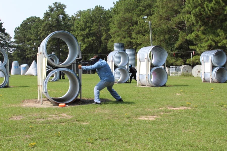 A man takes aim behind an obstacle at TXR Paintball. (Shawn Arrajj/Community Impact Newspaper)