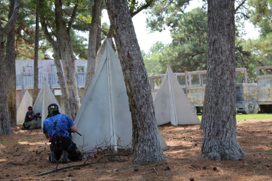 Two player on the same team communicate while taking cover during a match at TXR Paintball. (Shawn Arrajj/Community Impact Newspaper)