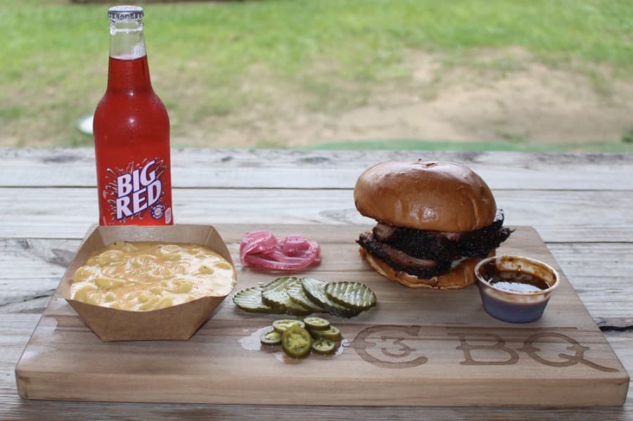 Sandwiches ($9) can be topped with any smoked meat, and can be accompanied by sides ($4) such as macaroni and cheese and bottled drinks ($2). Additional meat toppings ($5) are optional. (Ben Thompson/Community Impact Newspaper)