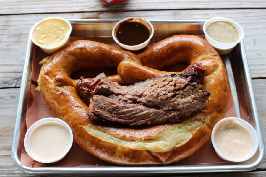 The restaurant's Twisted Tray ($18) features a half-pound of any smoked meat served on a Slow Dough Bread Co. pretzel, with a sampling of house-made honey mustard, beer cheese, chipotle ranch, barbecue and Alabama sauces. A portion of the tray's cost also benefits a new local charity each month through 3rd Coast's Twisted Together initiative. (Ben Thompson/Community Impact Newspaper)