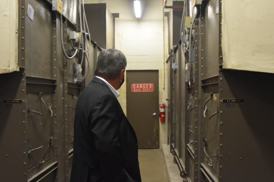 Mayor Paul Voelker tours the library's basement, which houses important utilities, such as the water system. It is in need of upgrades and maintenance, according to Shawn Poe, the city's capital projects director of engineering. (Makenzie Plusnick/Community Impact Newspaper)