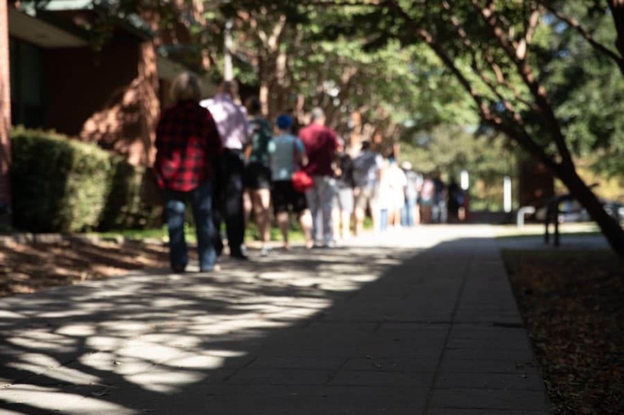 Voters are encouraged to keep a 6-foot distance from one another, causing lines to stretch farther than they typically would with the same amount of people. (Liesbeth Powers/Community Impact Newspaper)
