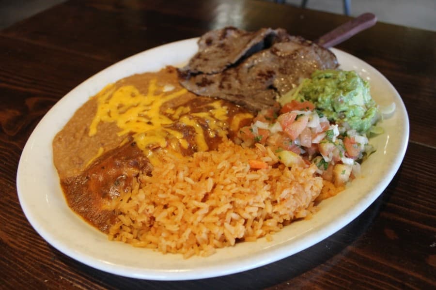 Carne asada with cheese enchilada: This marinated tenderloin is served with guacamole, pico de gallo, rice and beans. (Daniel Houston/Community Impact Newspaper)