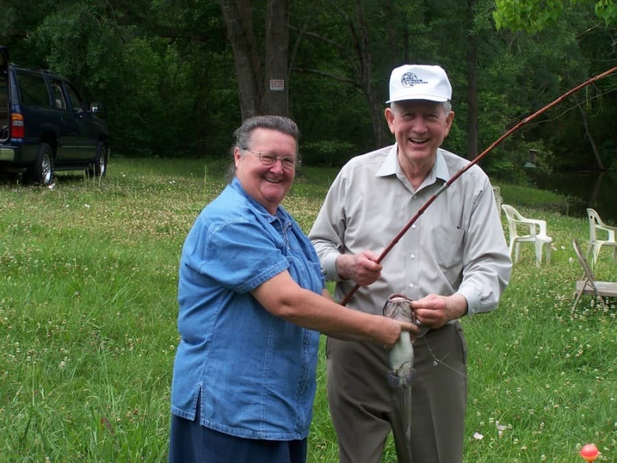 Deison poses with his former secretary, Linda Garner, after catching a catfish on her property. (Courtesy Larry Foerster)