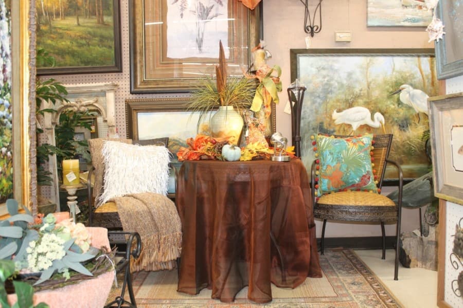 Randall Tate's wife Sandy arranges the home decor items in the store. (Colleen Ferguson/Community Impact Newspaper)