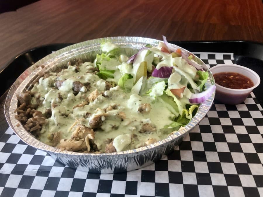 The popular "specialty over rice" dish is topped with creamy jalapeño sauce. (Sally Grace Holtgrieve/Community Impact Newspaper)