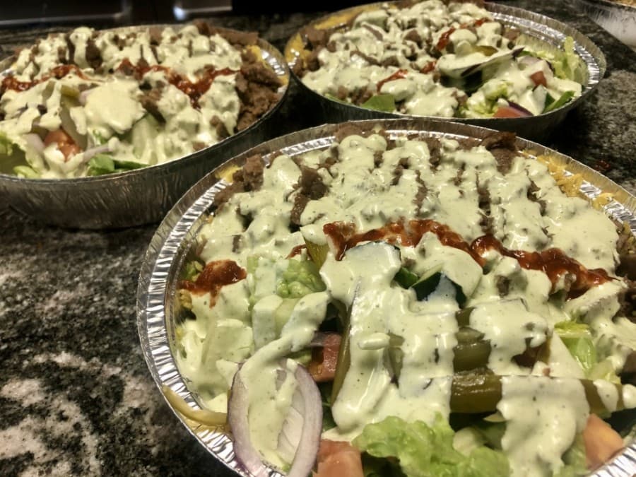 The popular "specialty over rice" dish is topped with creamy jalapeño sauce. (Sally Grace Holtgrieve/Community Impact Newspaper)