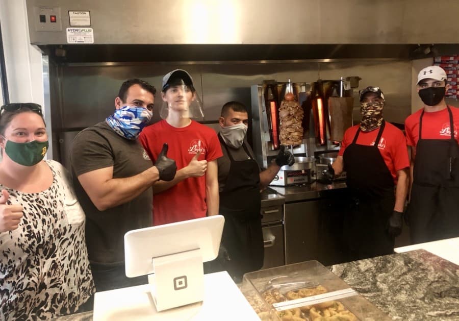 Courtney (left) and Alaa Bataineh stand with staff members behind the counter at Leyla's. (Sally Grace Holtgrieve/Community Impact Newspaper)