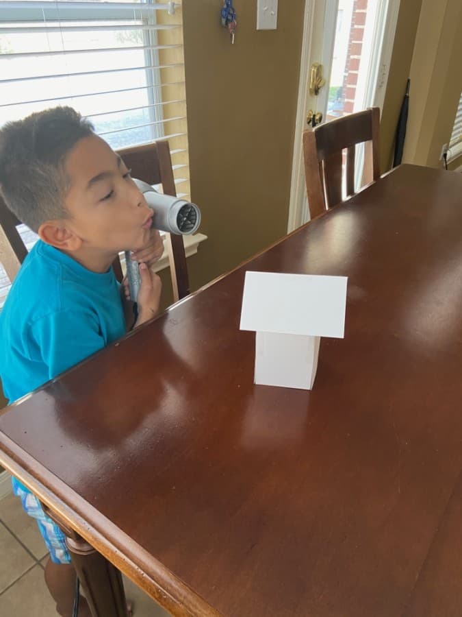 Hall Elementary Clear Connections student Julian Parks tests the durability of the house he built for Huff and Puff engineering lab. (Courtesy Clear Creek ISD)