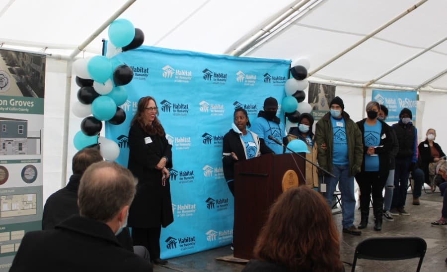 LaTonia Dashield, behind the podium, thanks those in attendance for their support of the Cotton Groves project. (Miranda Jaimes/Community Impact Newspaper)