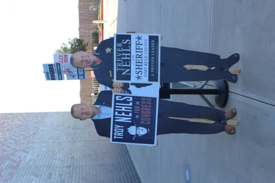 Voters passed a cardboard cutout of twin brothers Troy Nehls, the Republican candidate for U.S. House District 22, and Trevel Nehls, the Republican candidate for Fort Bend County sheriff. (Claire Shoop/Community Impact Newspaper)