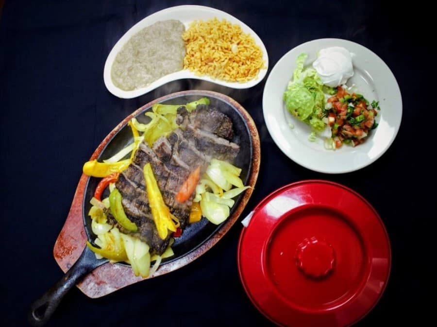 Beef fajitas ($16.25) come with marinated strips of grilled Angus steak sautéed with grilled onions and bell peppers. They are served with rice, beans, guacamole, pico de gallo and corn or flour tortillas. (Courtesy CasaMia Mexican Restaurant and Bar)