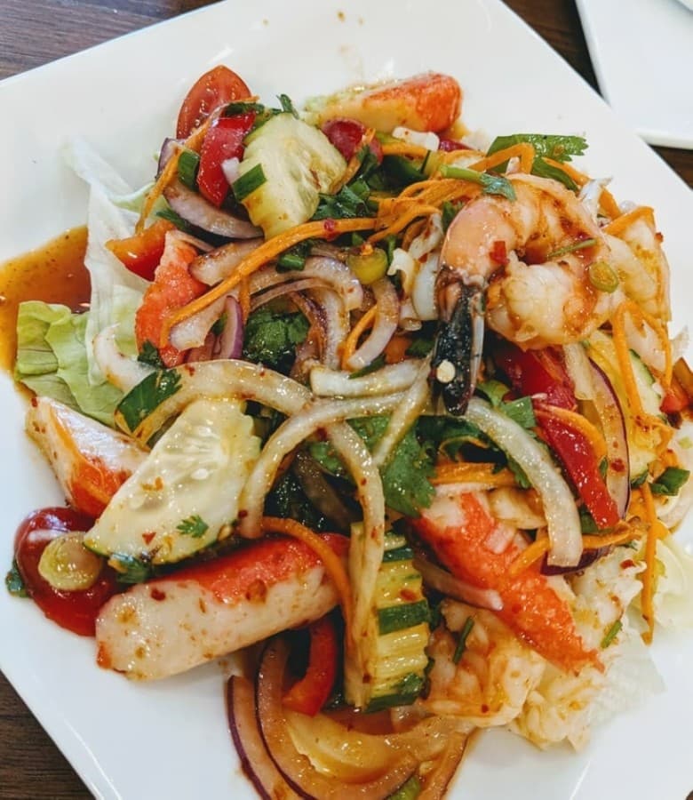 A combination of seafood items available at different spice levels are served with bell peppers, onions, carrot, cucumber, tomato and chili lime dressing. (Courtesy Thai Curry)