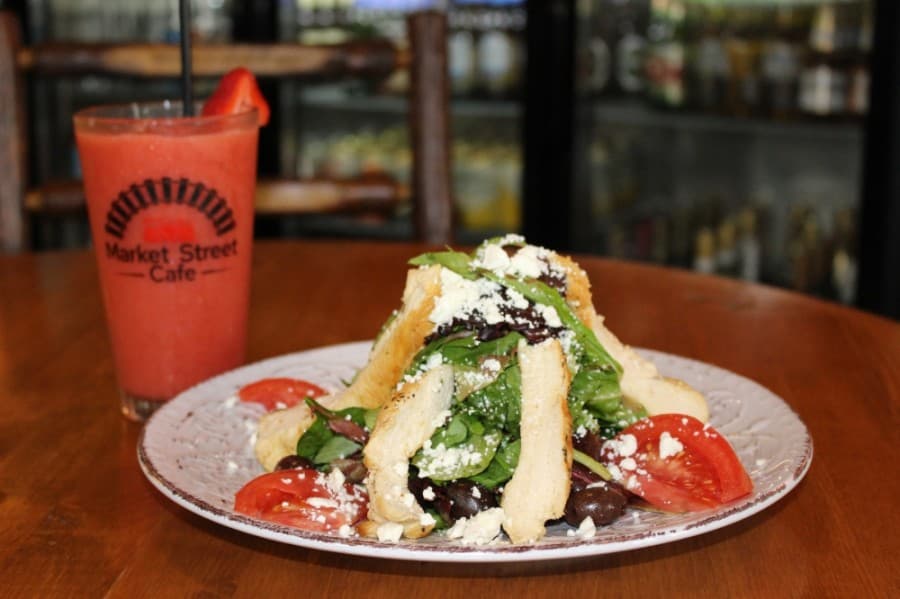 The Greek salad ($10.89) is served with baby greens, feta cheese, kalamata olives and other vegetables tossed in the Market Street Cafe Greek salad dressing. (Adriana Rezal/Community Impact Newspaper)