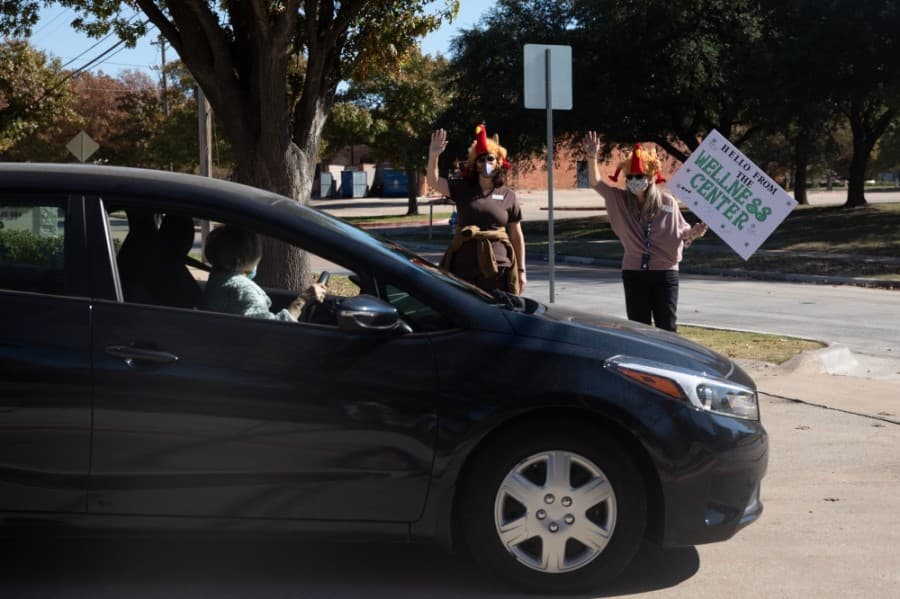 Roughly 100 members drove along a cone-lined path of city staff and council members bearing signs and smiles before opening their trunks for a staff-made, packaged meal at a Nov. 18 Thanksgiving event. (Liesbeth Powers/Community Impact Newspaper)