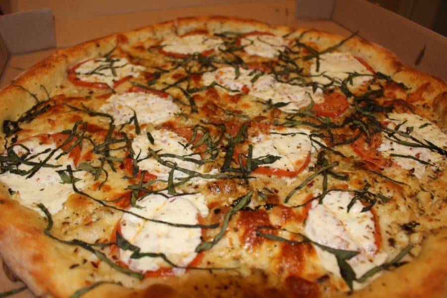 


Margherita pie ($20-$30) is a pizza topped with garlic sauce, tomato slices, mozzerella and basil. (Kelly Schafler/Community Impact Newspaper)