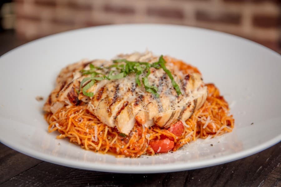 This pasta marinara, an angel-hair dish, is served with a choice of grilled chicken or meatballs, tomatoes, mushrooms and onions. (Courtesy Rustico Wood Fired Grill & Wine Bar)