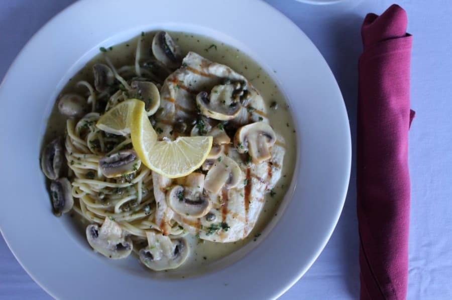 Chicken piccata ($15): •Chicken is served in a white wine and butter lemon sauce with mushrooms and capers. Substitute fettuccine Alfredo for $4. (Shawn Arrajj/Community Impact Newspaper)