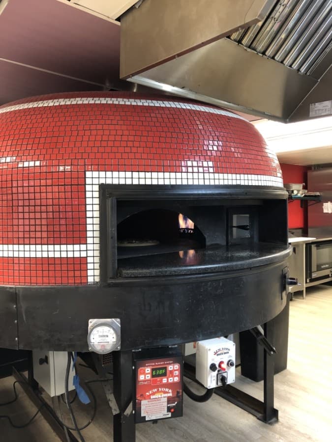 Pies are baked in Lake Travis Pizza's revolving brick oven. (Amy Rae Dadamo/Community Impact Newspaper)