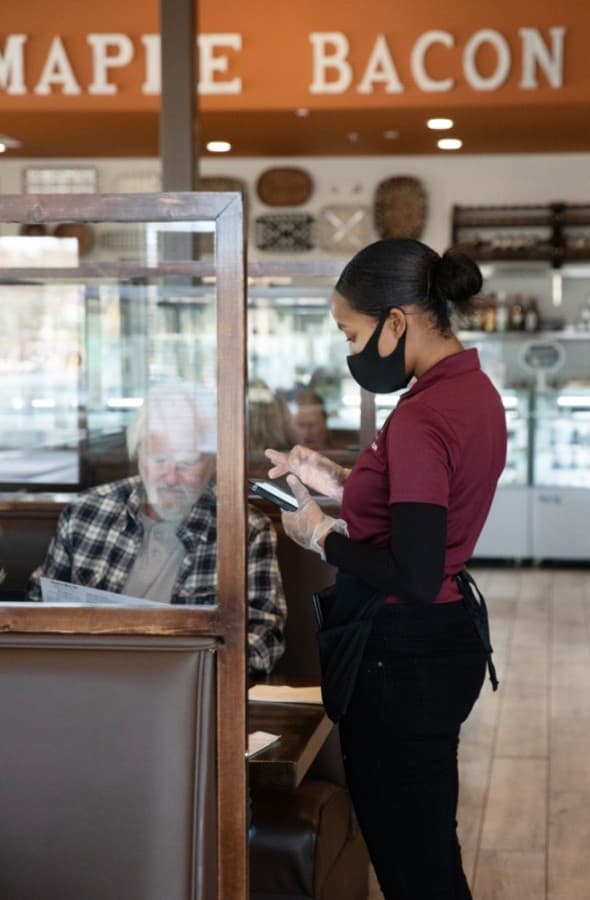Server Kristen Pierce takes food orders from diners Ken and Mary Jo Johnston in the early afternoon at Maple Bacon. (Liesbeth Powers/Community Impact Newspaper)