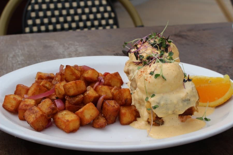 One of several Benedict options on the restaurant's menu, the fried green tomato and crab cakes Benedict ($16.99) features two crab cakes, two poached eggs and two fried green tomatoes served with remoulade and Cajun hollandaise sauces, and accompanied by fried potatoes topped with bell peppers, onions and herbs. (Ben Thompson/Community Impact Newspaper)