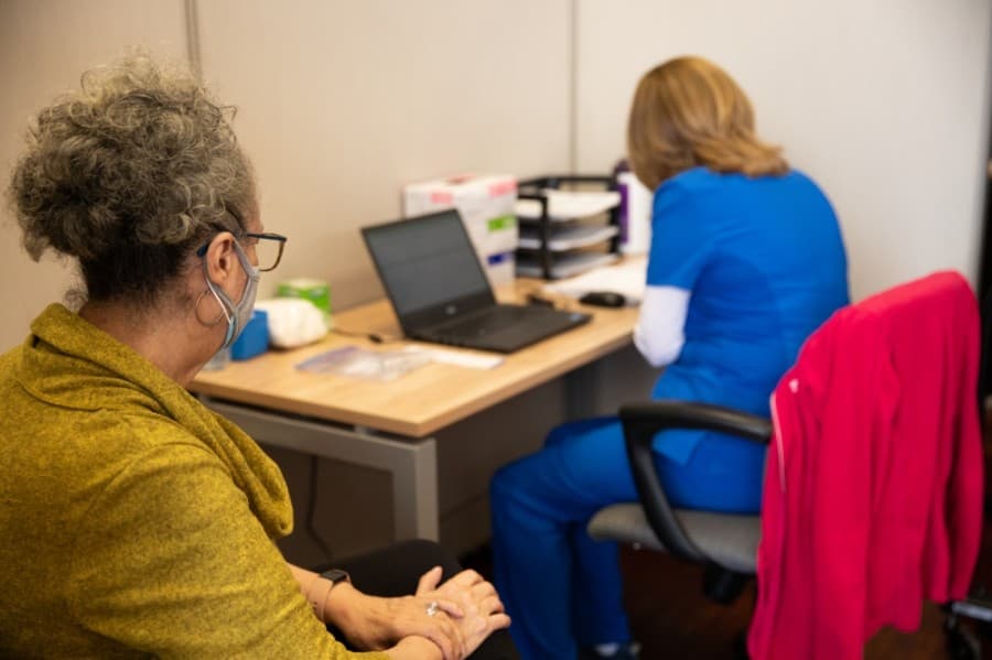 Plano resident Connie Cordova explains her patient history before receiving her first dose of the Pfizer COVID-19 vaccine Feb. 5. (Liesbeth Powers/Community Impact Newspaper)