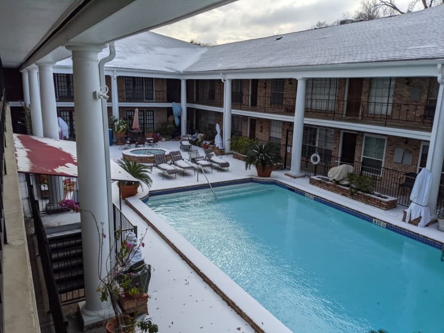 A snow-covered Montrose apartment complex overlooks an empty pool.