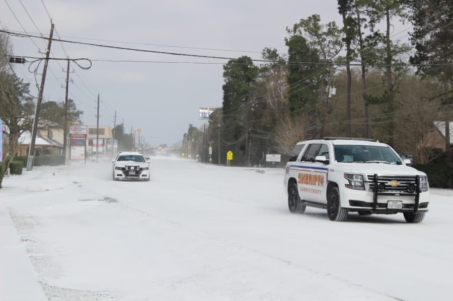 Harris County Sheriff's Department vehicles were among the few vehicles on snow-covered Cypresswood Drive in the Spring area Feb. 15. (Ben Thompson/Community Impact Newspaper)