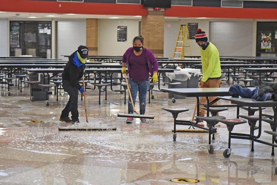 Restoration crews at Langham Creek High School work to clean up water from the floors following freezing temperatures this week that caused pipe damage to campuses. (Courtesy Cy-Fair ISD)