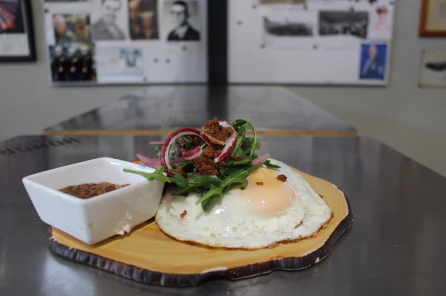 The avocado toast with egg ($9) includes grilled sourdough, cream cheese and bacon. (Eva Vigh/Community Impact Newspaper)