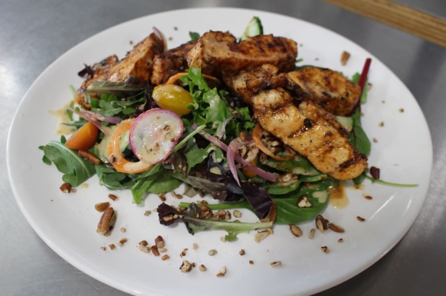 The smoked chicken salad ($13) is served on a bed of baby greens and cucumber. (Eva Vigh/Community Impact Newspaper)