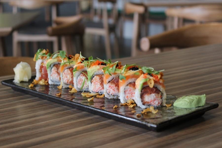 The Daddy Doo ($16) is a spicy tuna and crab mix sushi roll topped with salmon, avocado and masago. (Adriana Rezal/Community Impact Newspaper)